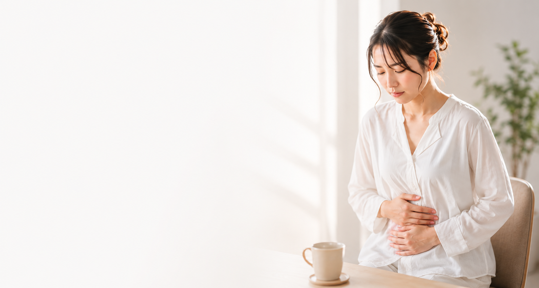 胃もたれでお腹を押さえる女性
